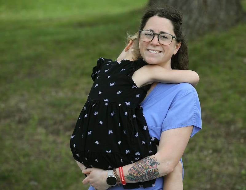 Kailee Schultz hugs her daughter on Tuesday, May 19, 2026, at their home in Johnsburg. Schultz was seven months pregnant with her daughter when a patient kicked her in the abdomen while working in the emergency room at Northwestern Medicine in McHenry.