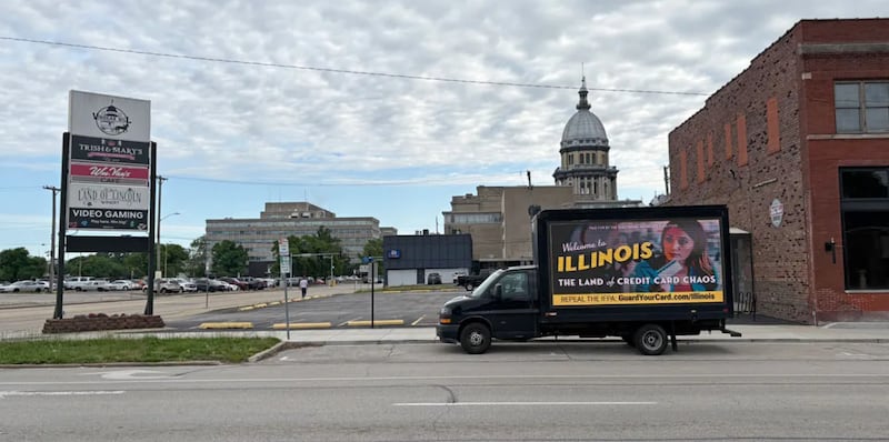 A “Credit Card Chaos” ad appears on a drivable billboard a few blocks from the Illinois Capitol during the legislature’s final stretch. The Illinois law that it targets suffered a pair of setbacks this week.