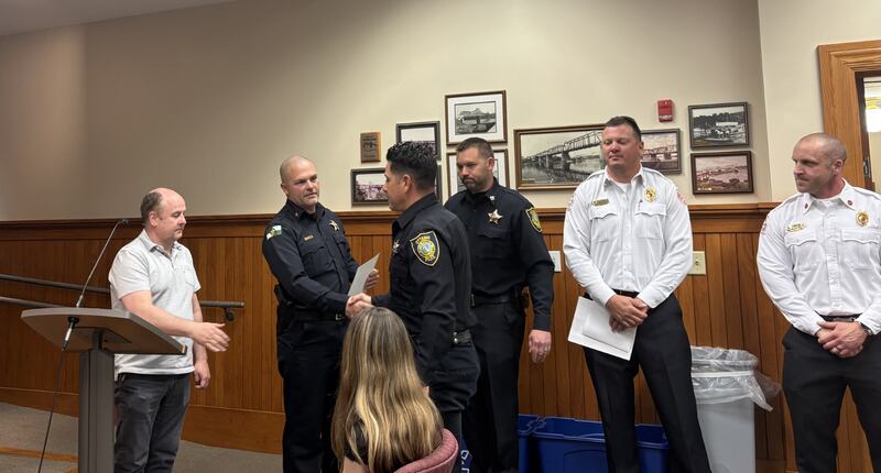 Officer Daniel Sovero shakes hands with Ottawa Police Chief Mike Cheatham after receiving a letter of commendation during a City Council meeting Tuesday, May 6, 2025. Sovero and Cpl. Adam Jobst, the initial first responders on scene, were among several honored for helping save a man who collapsed from cardiac arrest in March.