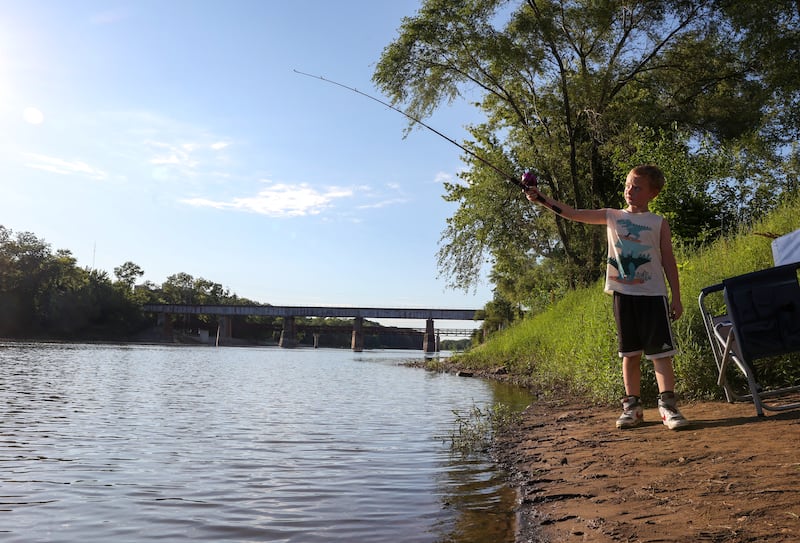 Kolton Baker, 7, of Bourbonnais, casts his line into the Kankakee River at Fisherman Park in Kankakee on Saturday, June 28, 2025, as he participates in the NIAA Kankakee River Fishing Derby with his mother, Chris Gankel, for the third year. Baker, who learned to fish through the Kankakee County State's Attorney's Office's Reel Justice Fishing Club, said he hopes to make the Big Board this year.