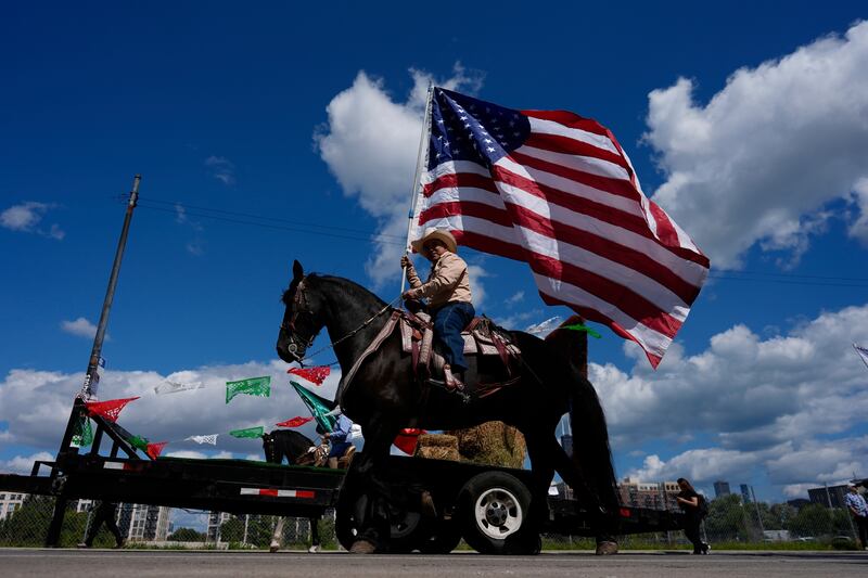 Participants wave flags during the 2025 Pilsen Mexican Independence Day parade Saturday, Sept. 6, 2025, in Chicago.