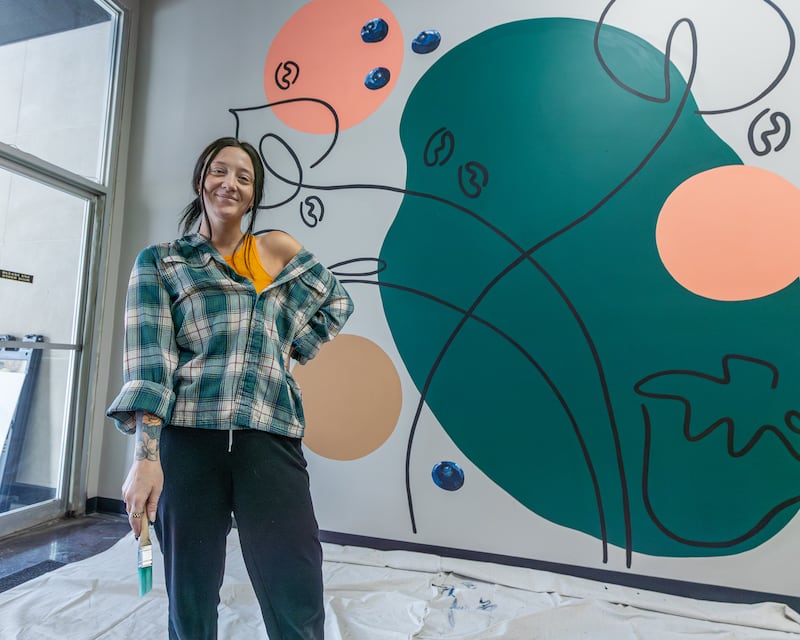 Lacey Haltenhof of 'The Laced Brush' poses for photo in front of her first ever mural project at More Cafe in Ottawa on Monday, Feb. 2, 2026. Lacey started working on the Mural Sunday Feb. 1 and finished the project Monday Feb. 2 just after 2 o'clock in the afternoon.