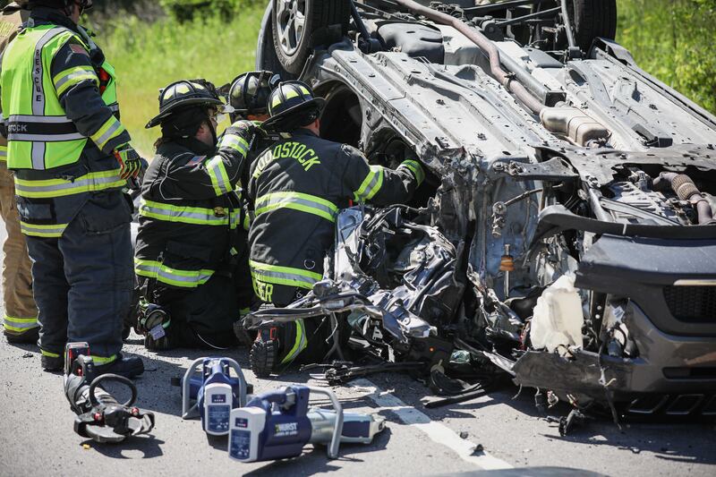 First responders work to extricate the driver at the scene of a rollover crash Monday, June 23, 2025 along Route 14 outside Woodstock.