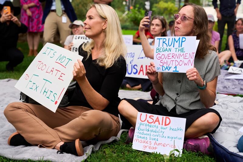 Layne Morrison, left, of Washington, and Courtney Creek, of Silver Spring, Md., who were let go from their jobs with the Education Department and a USAID funded grant respectively, hold signs about the looming government shut down, Tuesday, Sept. 30, 2025, on Capitol Hill in Washington, during a rally with former federal employees. (AP Photo/Jacquelyn Martin)