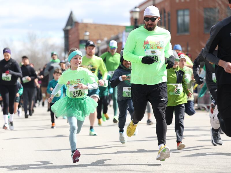 Dan Ulaszik and his 9-year-old daughter Peyton run in the 3rd annual Plainfield Paddy Day Mile run before the start of the Plainfield Hometown Irish Parade on Sunday, March 17, 2024 in Plainfield.