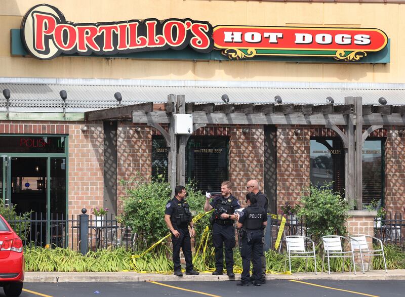 Law enforcement officers talk Wednesday, July 30, 2025, at the scene where a car crashed through the front entrance of the Portillo’s at 2810 U.S. Route 34 in Oswego injuring 12.