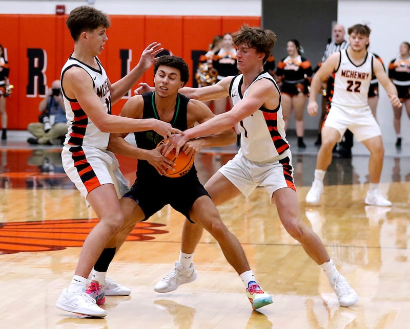Crystal Lake South's Anthony Demirov is double teamed by McHenry's Caleb Jett (left) and Dylan Hurckes during a Fox Valley Conference boys basketball game on Wednesday, Dec. 11, 2024, at McHenry High School.