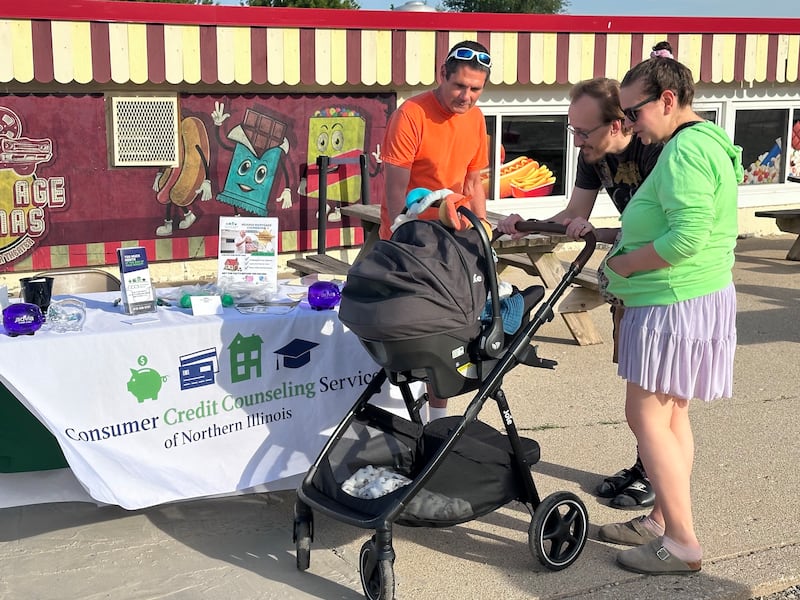 Payton and Taylor Gehm, along with 3-month-old Troy, chat with Jim Kearns of the Consumer Credit Counseling Service of Northern Illinois during a recent Project Popcorn night at the McHenry Outdoor Theater. Each Wednesday through Aug. 5, a group of area nonprofits is featured.