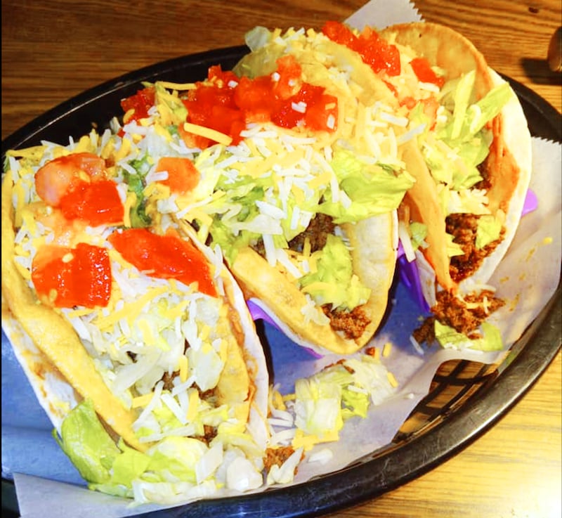 The double taco basket consists of three hardshell tacos wrapped inside softshell tortillas lined with beans.