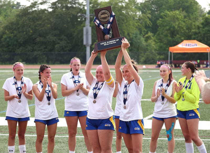 Johnsburg players hoist the state second place trophy Saturday, June 7, 2025, after their IHSA Class 1A state championship game loss to Columbia at North Central College in Naperville.