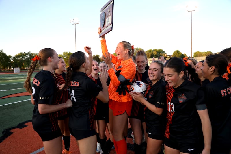 St. Charles East's Sidney Lazenby holds up the plaque as the Saints celebrate their Class 3A St. Charles East Regional final win against Geneva on Friday, May 23, 2025 in St. Charles.