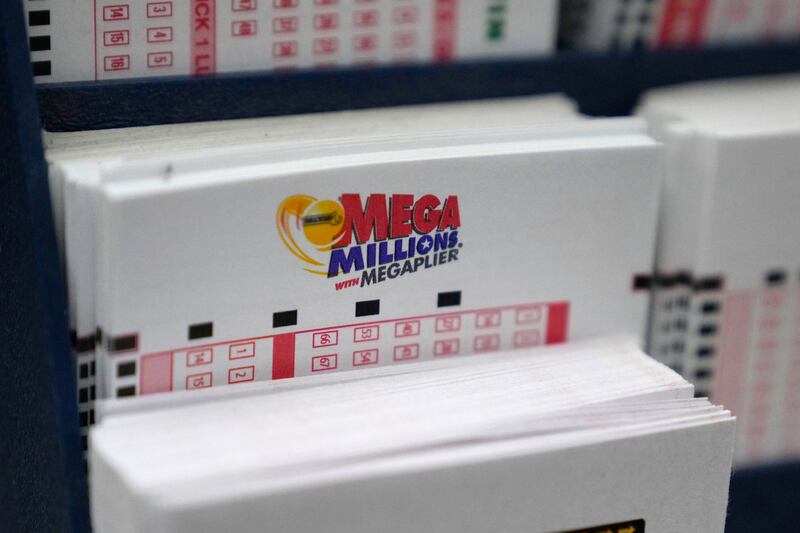 A display holds Mega Million lottery ticket wagering cards at Ted's State Line Mobil station, Thursday, Jan. 5, 2023, in Methuen, Mass. Twenty-three consecutive drawings later with no grand prize winner named, the Mega Millions jackpot is now flirting with nearly $1 billion, making it one of the largest jackpots in lottery history. (AP Photo/Charles Krupa)