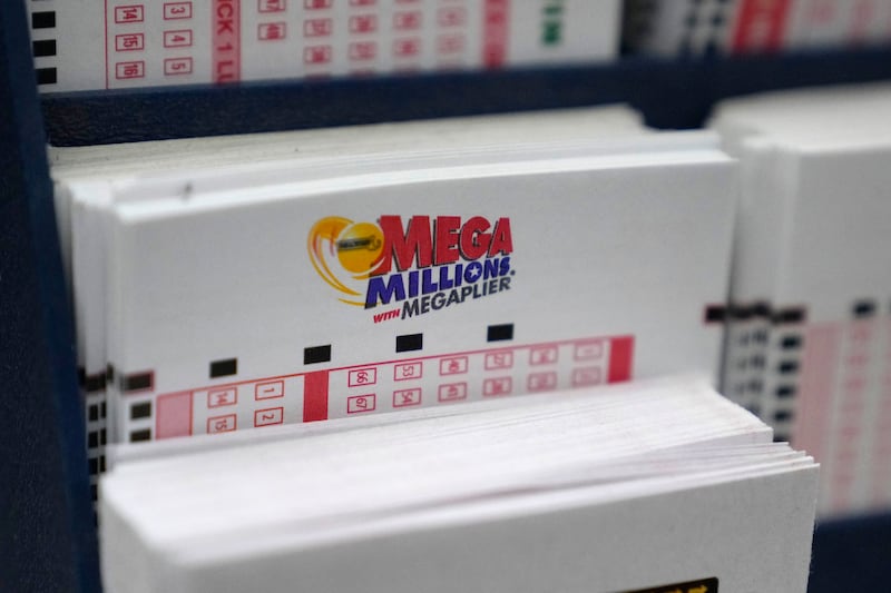 A display holds Mega Million lottery ticket wagering cards at Ted's State Line Mobil station, Thursday, Jan. 5, 2023, in Methuen, Mass. Twenty-three consecutive drawings later with no grand prize winner named, the Mega Millions jackpot is now flirting with nearly $1 billion, making it one of the largest jackpots in lottery history. (AP Photo/Charles Krupa)