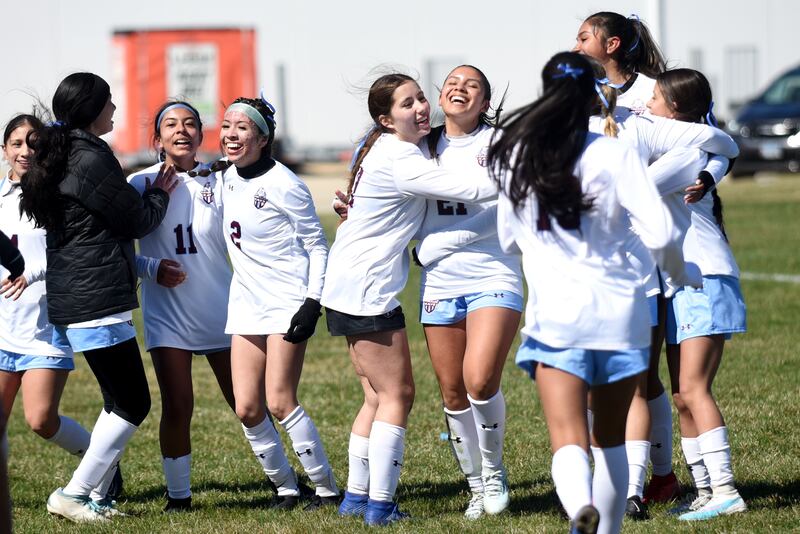 Members of the Kankakee girls soccer team celebrate the program's first-ever win against All-City rival Bishop McNamara, a 2-1 win at McNamara Saturday, March 22, 2025.