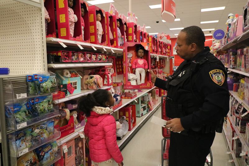 Officer Josef Gordon (right) grabs a toy from the top shelf for Syree Miles, 6, Dec. 15, 2024, during a shopping spree. Gordon accompanied Miles during the DeKalb Police Department's annual Heroes and Helpers event.