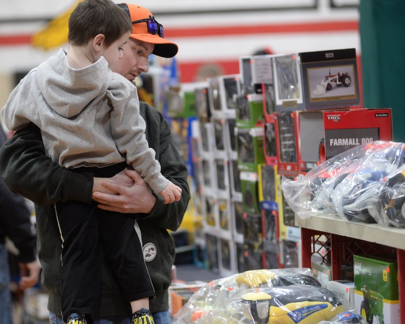 Brian Koeller holds Clay Beach, 3, of Forreston, as they look. over some of the items for sale at the Forreston FFA Alumni's Farm Toy and Craft Show on Saturday, March 8, 2025. The event was held at the Forreston High School.
