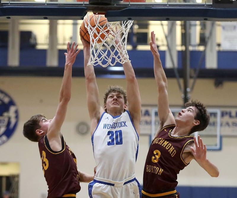 Woodstock's Ty Steponitis (center) drives to the basket between Richmond-Burton's William Gardner (left) and Richmond-Burton's Dane Gardner (right) during a Kishwaukee River Conference boys basketball game on Wednesday, February. 4, 2026, at Woodstock High School.