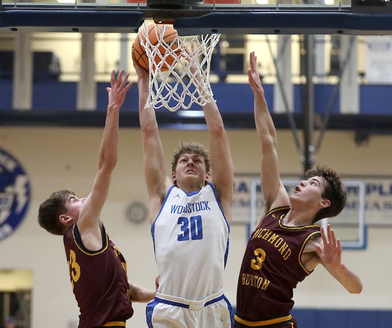 Woodstock's Ty Steponitis (center) drives to the basket between Richmond-Burton's William Gardner (left) and Richmond-Burton's Dane Gardner (right) during a Kishwaukee River Conference boys basketball game on Wednesday, February. 4, 2026, at Woodstock High School.