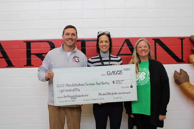 Brandon Scheppers, Sarah Henkel, and Shasta Hladovcak present an $850 donation to the Mendota Area Christian Food Pantry.
