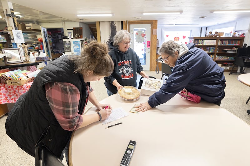 Nancy Wallahan (right) pays up for cinnamon rolls and a strawberry pie Friday, Feb. 13, 2026, from Teen Turf representatives Amber Horner (left) and Eileen Piper.