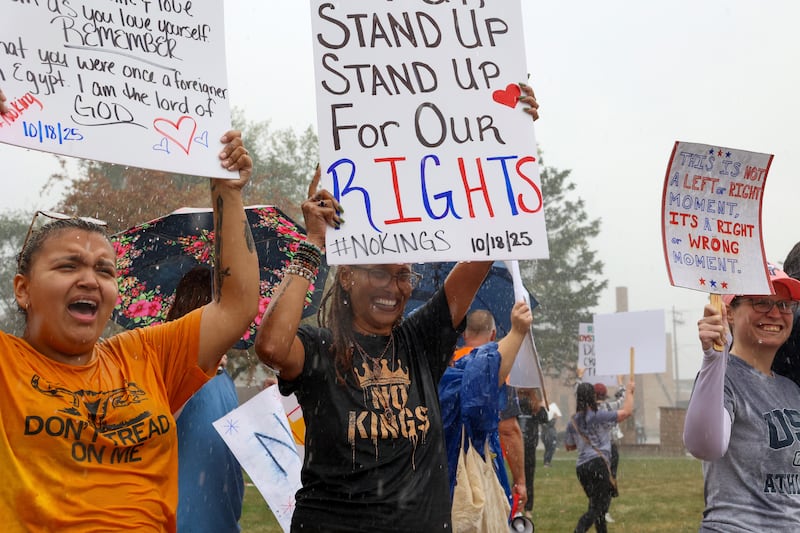 Ashley Punis, center, of Kankakee, protests through the rain at the Kankakee County Courthouse during the No Kings Rally on Saturday, Oct. 18, 2025.