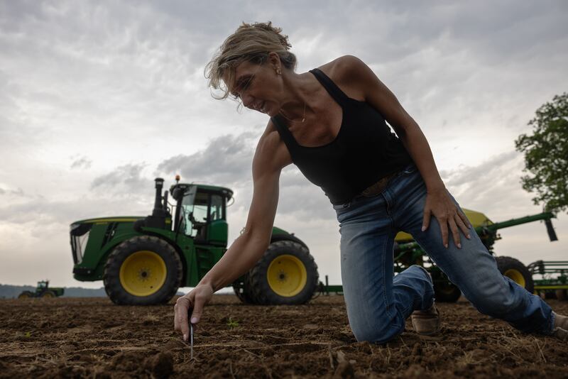 Brandy Renshaw checks the depth of her soybean seeds while a storm rolls in. Increased flooding has made some of the land she and her father farm nearly unusable.