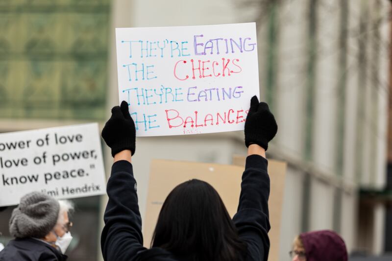 An attendee holds up a sign at the Hands Off protest in downtown Joliet on Saturday, April 5, 2025. The rally was part of a nationwide movement to protest policies and actions of the Trump administration and Elon Musk on Saturday.