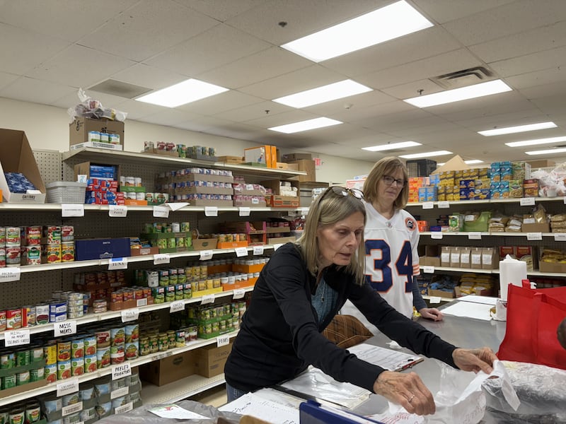 Woodstock Food Pantry volunteers Pat Tiger, left, and Mary Pletch help a client Oct. 31, 2025.