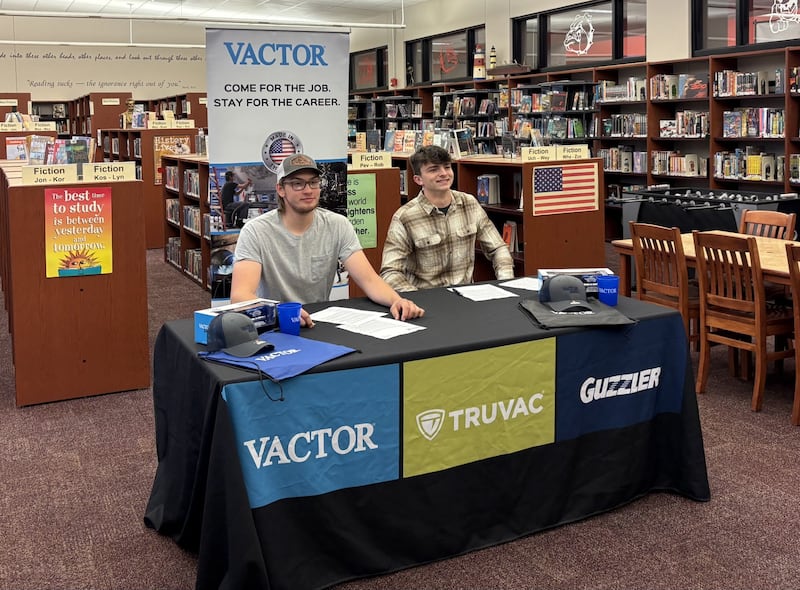 Jaxin Goodrich (left) and Aaron Henson (right) sign their letters of intent to begin full-time employment with Vactor Manufacturing during a signing ceremony at Streator High School on Tuesday, May 20.