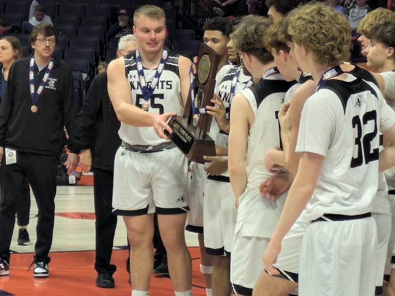The Kaneland basketball team celebrates with the third-place trophy after beating Leo 35-32 on Friday, March 13, 2026 in Champaign.