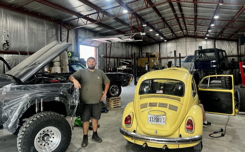 Steel Town Speed owner Tyler Felder stands among his custom classic car builds in Rock Falls, Illinois.