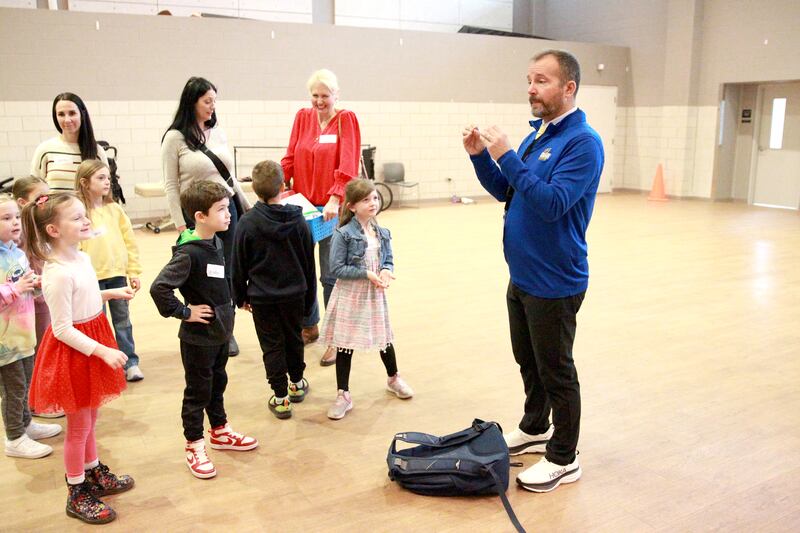 Grace McWayne Elementary School teacher Chad Clarey directs teaches students the sign for “more” during a visit to the Marklund Hyde Center in Geneva, where students made valentines and read to the clients.