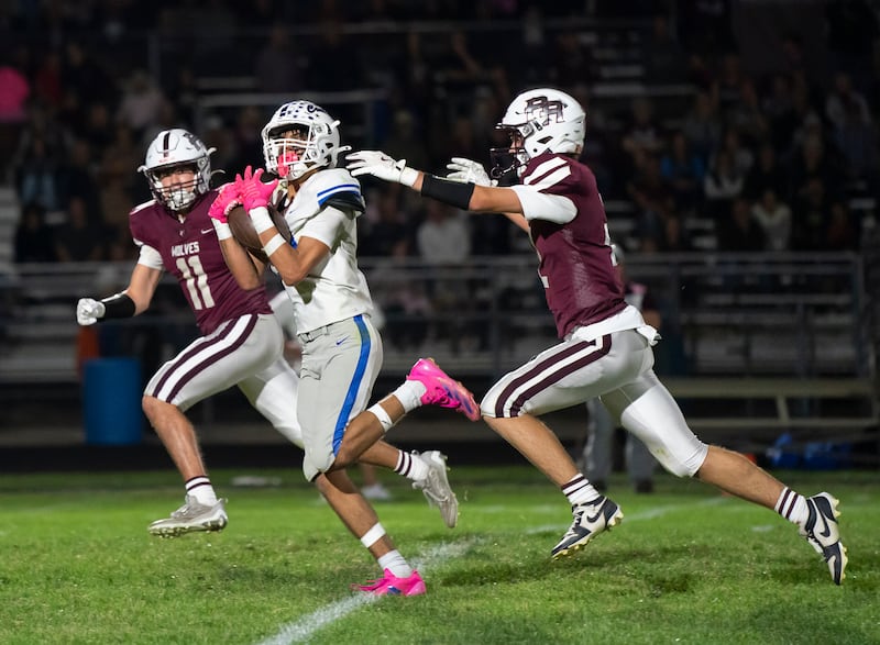 Burlington Central's Rocco Boss catches a pass under pressure from Prairie Ridge's Ben Gablenz, left, and Logan Thennes during their Fox Valley Conference game on Friday, October 11, 2024 at Prairie Ridge High School in Crystal Lake. Ryan Rayburn for Shaw Local