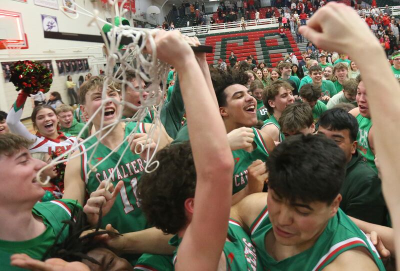 Members of the L-P boys basketball team hoist the Class 3A La Salle-Peru Regional title plaque after defeating Streator on Friday, Feb. 28, 202,5 in Sellett Gymnasium at L-P High School.