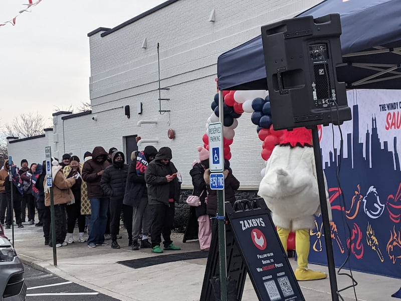 Customers stand in frigid temperatures for the chance to win free chicken for a year from the newly opened Zaxby’s restaurant in Plainfield during a grand opening celebration on Tuesday, Feb. 24, 2026.