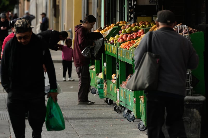 A person shops for produce at a market in San Francisco on Saturday, Nov. 15, 2025. (AP Photo/Jeff Chiu)