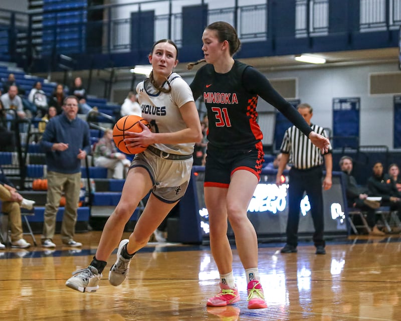 Oswego East's Aubrey Lamberti (1) drives to the basket past the defense of Minooka's Madelyn Kiper (31) during their basketball game between Minooka at Oswego East Friday, Jan 16, 2026 in Oswego.