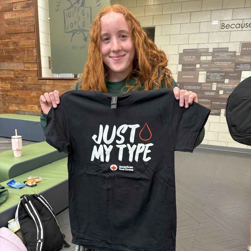 St. Bede Academy junior Lillian Soliman holds up her free T-shirt from the American Red Cross after donating blood at St. Bede’s community blood drive on Feb.11, 2025.