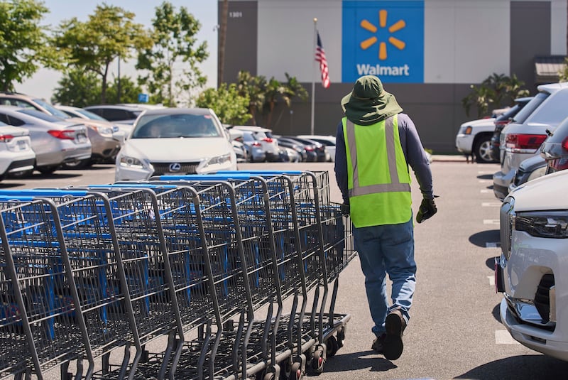 FILE - Empty shopping carts are collected from the parking lot at Walmart store in Burbank, Calif., on Thursday, April 10, 2025. (AP Photo/Damian Dovarganes, File)