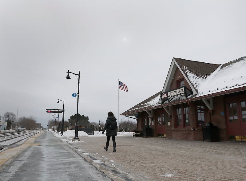 A person walks to the other side of the tracks to wait for a train Thursday, Feb, 3, 2022, at the Metra station in downtown Crystal Lake. Crystal Lake and Cary are in the considering purchases their downtown stations after Union Pacific decided to sell this station and other commuter stations.