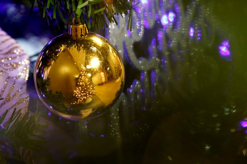 A Christmas tree is reflected in the ornament installed on another tree on Thursday, Nov. 21, 2024.