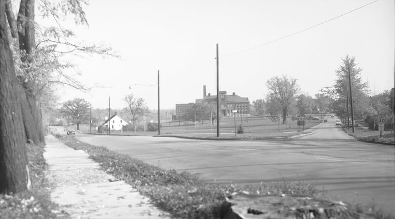 DeKalb High School looking northeast from First Street at Sycamore Road just before the home at 604 North First was removed, October 1965.