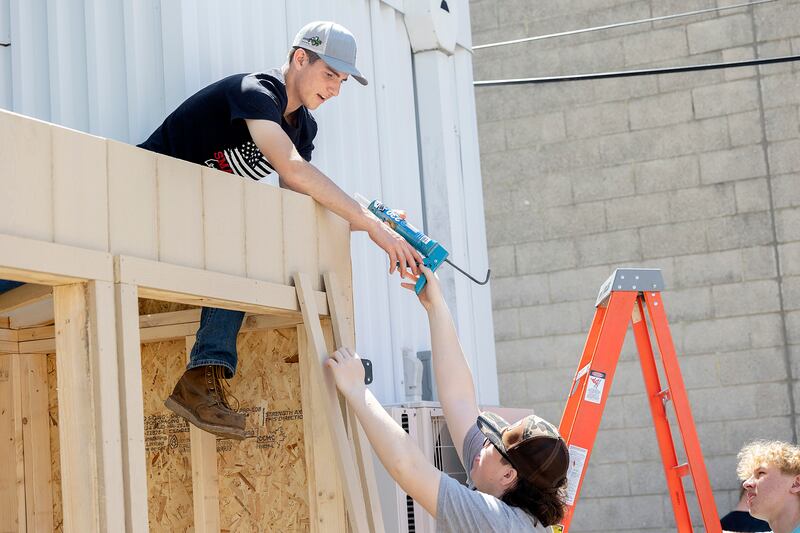 Oregon High School Ag Construction class members Cameron Folk (left) and Kaimana Barcai work on mini-food center construction Friday, May 16, 2025, at Dixon Public Library.