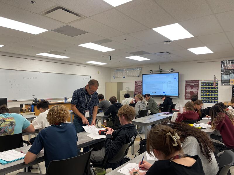 Bob Champlin works with an LTHS students on a physics problem.