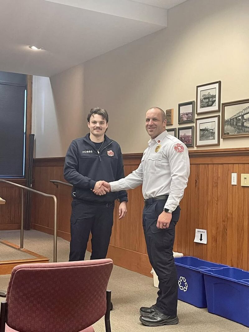 Firefighter Derrick Hobbs shakes hands with Deputy Fire Chief Michael Mills during his swearing-in ceremony as Ottawa Fire's newest probationary firefighter.