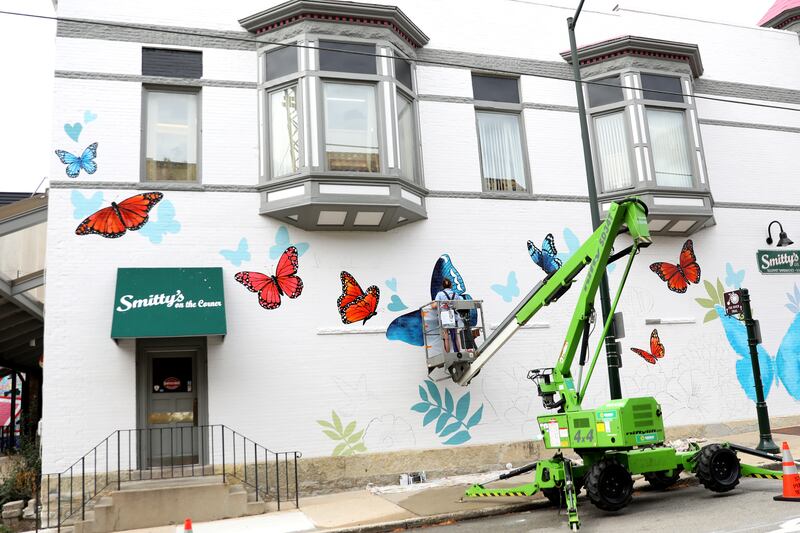 Artist Catherine Tilly works on a mural located on the east side of Smitty’s sandwich shop on Monday, Sept. 23, 2024 in downtown St. Charles. Kendall's Kindness is commissioning  the piece.