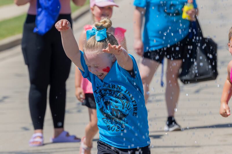Paizlee Peltier, 5, of Rock Falls blasts through a shower of water Saturday, June 28, 2025, at Rock Falls' Touch-a-Truck event.