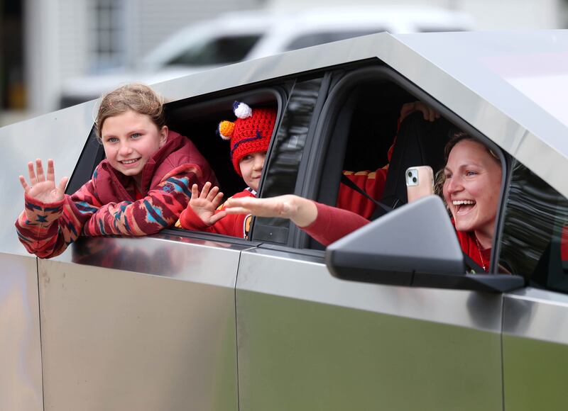 (From left) Carolynn Morong, her brother Marshall Morong and mom Jessica Satdei wave from a Tesla Cybertruck to a crowd waiting to welcome Marshall to Hinckley-Big Rock Elementary School Monday, May 5, 2025. Marshall returned to school months after receiving a heart transplant.