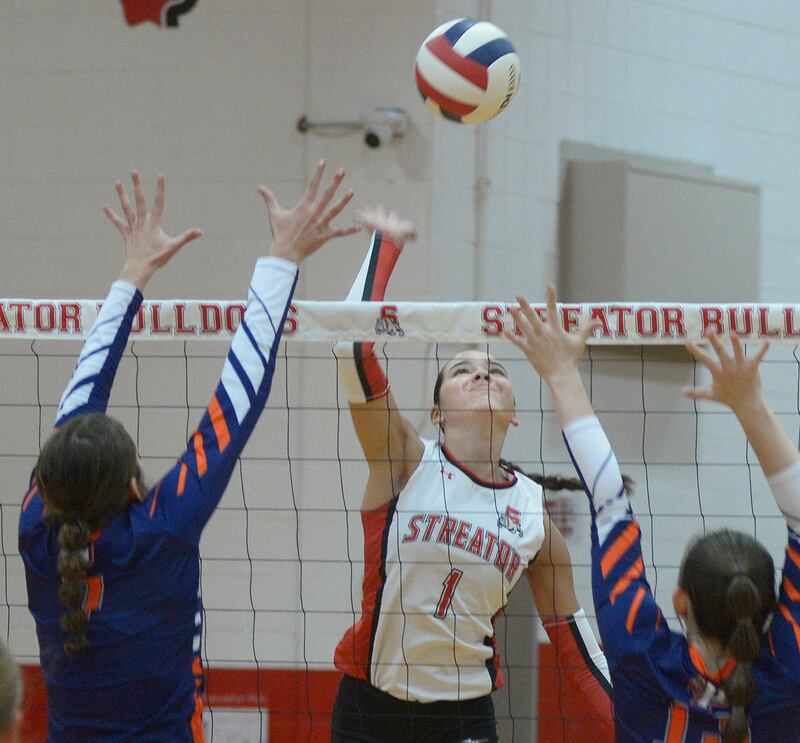 Streator’s Aubrey Jacobs sets to get the ball past the blocks of Pontiac’s Trinity Cheek and Sophia Karr in the first set Wednesday at Streator.