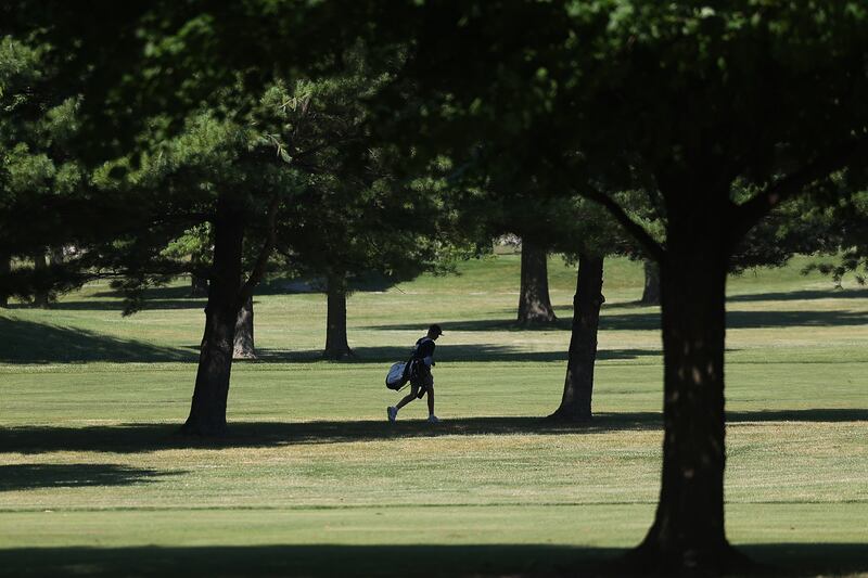 A golfer utilizes shade from the trees as they walk the fairway at Inwood Golf Course in Joliet on Friday, June 21, 2024.